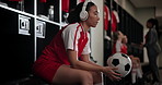 Woman, headphones and music in locker room for inspiration with vision, streaming or listen with football. Person, athlete or soccer player with audio, subscription or sound with thinking for contest