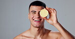 Happy man, skincare and lemon for morning routine, natural cosmetics and grooming for hygiene or wellness. Male person, citrus fruit and studio background in dermatology, healthy diet and vitamin c