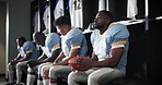 Serious men, football players and team captain with ball in locker room for match, game plan or half time. Young people or group of sports athletes in break, row or line for tournament or competition