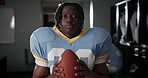 Football, sport and black man with ball in locker room for match, game preparation and ready for tournament. Player, professional athlete and portrait in cloakroom with determination for competition