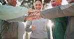 Senior, group and woman with hands together in park for fitness motivation, team building and support for health. Elderly people, caregiver and pile gesture in nature for wellness success or teamwork