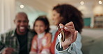 Hand closeup, keys and family in new home for real estate investment, loan or mortgage. Property, mother and father with child moving to dream house and show keychain to celebrate relocation or rent