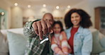 Hand, keys and family in new home for mortgage, loan or real estate investment. Property, mother and dad with child moving to dream house closeup to show keychain to celebrate relocation success