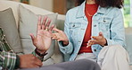 African couple, hands and argument on sofa in home for disagreement, communication problem and relationship discussion. Man, woman and together with conflict in house, emotional stress and dispute.