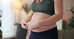 Measuring tape, pregnancy and woman with belly in home for checking growth of baby for health. Mother, maternity and pregnant female person with prenatal care for wellness and progress of fetus.