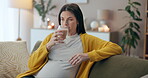 Coffee, relax and thinking with pregnant woman on sofa in living room of home for maternity wellness. Break, drink and smile of happy mother with glass in apartment for comfort, pregnancy or rest