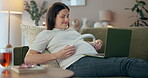 Belly, laptop and music with pregnant woman on sofa in living room of home for baby bonding. Headphones, health and streaming with happy mother in apartment for development or pregnancy wellness