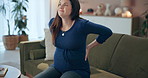 Home, pregnant woman and back pain on sofa, stomach and healthcare stress in living room. Apartment, motherhood and maternity with labour, cramps or inflammation with bruise, sore and agony in lounge