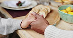 People, holding hands and prayer with food for celebration with gratitude, spiritual hosting and respect of reunion. Family, praying and worship god for eating together, support and thanks at house