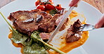 Steak, eating and meal in restaurant, knife and plate of fine dining in hotel, hospitality and beef. Kitchen counter, menu and meat on table for cuisine of culinary skills in food industry and hands