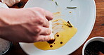 Hands, plate and sauce with bread as ingredient for meal in hospitality industry or restaurant. Person, table and food and wiping for preparation with creativity for presentation, serving and starter