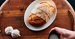 Person, hand and bread with ingredients for meal, breakfast or serving on wooden table above. Top view of whole wheat snack or chef with tasty toppings, butter or salt for lunch, dinner or light dish