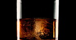 Glass, cube and ice with closeup, alcohol and bourbon on black studio background. Empty, cold and smooth drink with refreshment, pouring and whiskey with scotch, luxury and liquor with rum and cognac