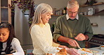 Senior, couple and prepare food for thanksgiving in kitchen with family, happiness and feast for festive celebration. Elderly people, child and together in house with turkey, embrace and conversation