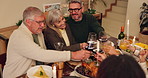 Happy family, toast and dinner for thanksgiving in home with love, food and thankful for holiday celebration. People, conversation and table with laughter or embrace, feast and reunion with relatives