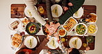 Above, family and huddle on dinner for thanksgiving for support, unity and solidarity. People, food and table at home to feast with unity, support and care on gathering for love, bonding and together