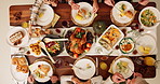 Dining table, food and hands of people at thanksgiving dinner with chicken, vegetables and juice. Meal, dinner and family at festive event, party or celebration gathering for supper from above.