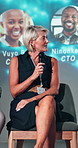 Conference, microphone and businesswoman on a stage at event for financial forecasting forum. Speaker, presentation and finance executive with revenue, profit or dividend of shareholders discussion.