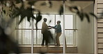 Senior couple, dancing and together in home with love, bonding and moving with connection in retirement. Elderly man, woman and holding hands with steps by window with pov by trees at apartment