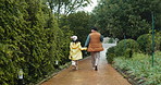 Father, girl and walk in park, holding hands and back in winter, rain and trees in nature with bonding. Dad, child and together with love, care and connection on path, outdoor and vacation in Canada