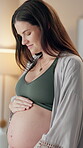 Woman, pregnant and happy with touching stomach at home for bonding, care and support. Female person, maternity and smile or satisfied with health, wellness and wellbeing with gratitude for pregnancy