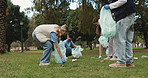 Trash, cleaning and volunteers in park for recycling with community service, waste or garbage pollution. Charity, bags and ngo employees tidying grass of dirt for eco friendly project in environment.