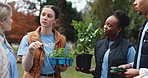 Nature, walking and group of volunteers with planst in park for community service, sustainability or gardening. Charity, outdoor and male ngo team with leaves for eco friendly outreach project.