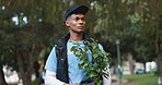 Nature, walking and volunteer with plant in park for community service, sustainability or gardening. Charity, outdoor and male ngo worker with leaves for eco friendly outreach project in Mexico.