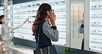 Woman, optometry and choosing glasses for eye care, consultation and optometrist with shopping retail. Female person, spectacles and option in clinic or ophthalmology center for size, frame and lens