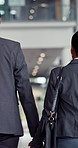 Holding hands, couple and business people in airport for travel, journey or international work trip. Connection, partnership and back of professional man and woman walk to terminal for company flight