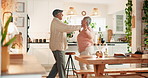 Senior, couple and happy with dancing in kitchen for favorite song, retirement wellness and kissing in home. Elderly, people and celebration together in house with romance, support or radio playlist
