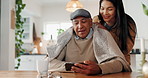 Care, blanket and woman with senior father in home watching movie, film or show online. Coffee, love and female person helping elderly dad with comfy throw for streaming video on phone in house.