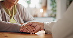 Senior people, empathy and support with holding hands, assistance or grief in nursing home or retirement. Elderly man, woman and wellness for compassion in living room for love, care or communication