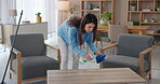 Cleaner, woman and wipe table with spray bottle for cleaning service, bacteria and household maintenance in home. Housekeeping, person and liquid chemical for dirty surface, hygiene and dust in house