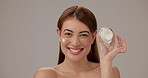 Face cream, skincare and face of woman in studio with natural, hydration and elasticity. Beauty, moisturizer and person from Thailand with dermatology routine for smooth texture by gray background.