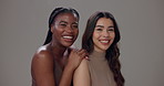 Happy, women and face with skincare in studio for cosmetics, treatment and solidarity on gray background. Friends, smile and people with hug for natural beauty, dermatology shine and facial results