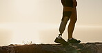 Legs, walking and prosthetic limb for hiking on mountain for exercise, workout and health with sunset. Closeup, fitness and person with a disability outdoor for adventure, hobby and rehabilitation