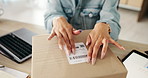 Business woman, hands and label with box in logistics for delivery, supply chain or packaging order on desk. Closeup of female person wrapping parcel, cargo or product for shipment or courier service