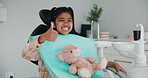 Oral care, child and thumbs up in office with smile, teddy bear and ready for procedure. Young girl, portrait or happy with gesture for approval, thank you or confident for dental hygiene in practice