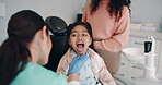 Woman, dentist and girl with mother for oral care, teeth hygiene and treatment or removal. Doctor, patient and parent on consultation for extraction at medical clinic on canal procedure or surgery