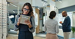 Woman, optometry and thinking with tablet, glasses and eye care as specialist, medical professional or optometrist. People, tech and advice in clinic or ophthalmology center for size, frame and lens