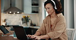 Laptop, house and woman with headphones, typing and singing with audio, listen to music and stress relief. Pc, person and girl with headset, student and sound with song, research and radio in lounge