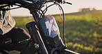 Motorbike, grass field and rider with nature in extreme sport, off road race or countryside terrain. Closeup, biker and stationery motorcycle with handles or suspension for break, start or steering