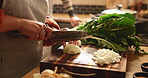 Hands, person and cooking in home kitchen with meal prep, healthy dinner and vegetable ingredients. Cutting, food and fresh produce with onions, spinach and vegan recipe for nutrition and wellness