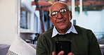 Senior man, phone and video call in home for communication, talking or share update. Retirement, happy person and virtual chat on internet with contact for conversation, news or story in living room