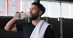 Man, tired and drinking water at gym, hydration and bottle of mineral liquid for nutrition. Male person, breathe and beverage for dehydration in workout, relax and aqua for fitness detox at club