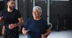 Elderly woman, running and gym with coach in class for wellness, support and cardiovascular exercise. Happy, senior person and trainer with workout in lesson for mobility, training and joint health