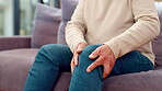 Elderly person, legs and knee pain on sofa with stress, anxiety and massage joint for relief. Senior man, injury and muscle ache in home with tension, physical therapy or osteoarthritis in retirement