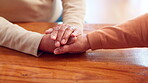 Senior people, grief and compassion with holding hands, support and assistance in nursing home or retirement. Elderly couple, bonding and empathy in living room for love, connection or communication