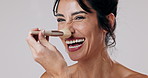 Makeup brush, happy and face of woman in studio with glow, natural and beauty cosmetology routine. Laughing, portrait and female person from Brazil with facial cosmetic tool by white background.